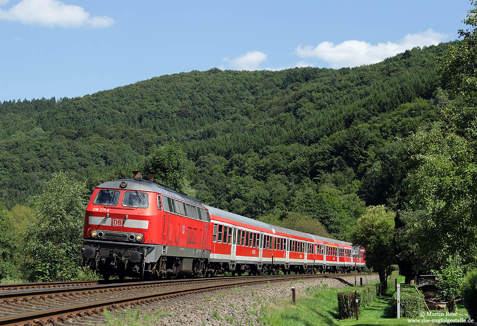 Nahe Mürlenbach eilt die 218 217 mit dem RE 12083 durch das schmale und kurvenreiche Kylltal. 4.8.2009