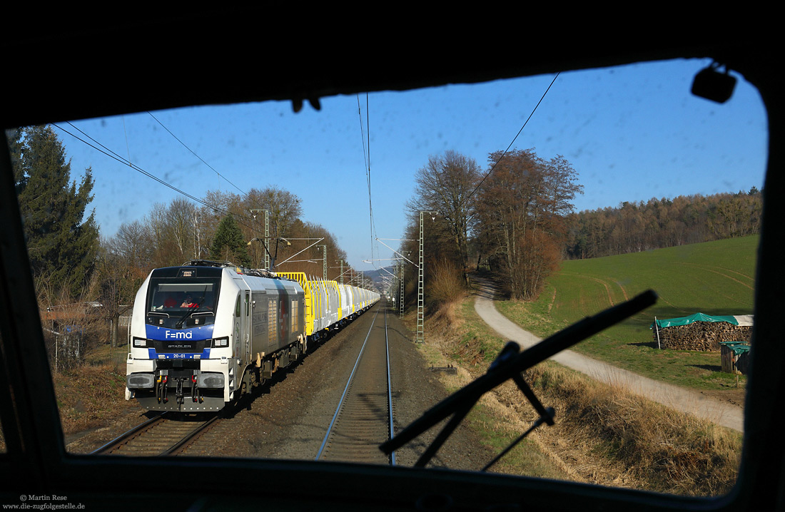 Bei Aschaffenburg Goldbach fährt die 20-01 (alias 259 201) von Heavy Haul Power International mit einem Rohholzzug gen Westen, fotografiert am 7.3.2022 aus der 103 245 des DB-Museums.