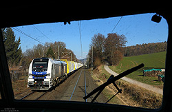 Bei Aschaffenburg Goldbach fährt die 20-01 (alias 259 201) von Heavy Haul Power International mit einem Rohholzzug gen Westen, fotografiert am 7.3.2022 aus der 103 245 des DB-Museums.
